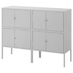 a white cabinet with four doors and two legs on the bottom, in front of a white background