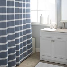 a bathroom with blue and white striped shower curtain