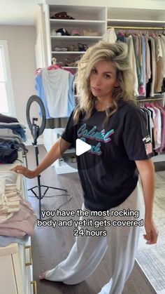 a woman standing in front of a clothes rack