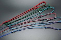 five different colored cords with beads on them