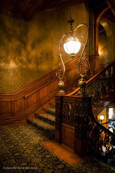 an ornate stair case with two lamps on it