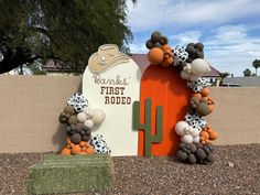 a sign with balloons attached to it in front of a fenced off area that has an orange door