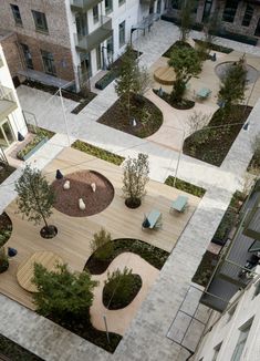 an aerial view of a courtyard with benches, trees and seating areas in the center