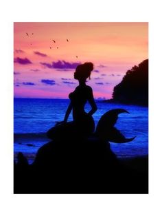 the silhouette of a woman sitting on top of a rock near the ocean at sunset