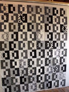 a black and white quilt hanging on the wall