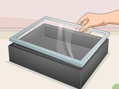 a hand is pointing at an empty glass box