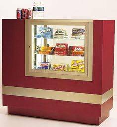 a red and gold vending machine with sodas in it's display case