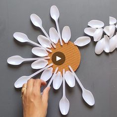 a person pointing at white spoons on top of a wooden board with an arrow in the center