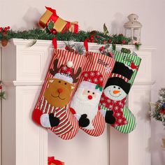 three christmas stockings hanging from a mantel decorated with snowmen, reindeers and santa hats