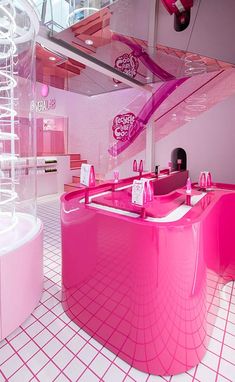 the interior of a pink and white store with lots of counter space, including a round sink