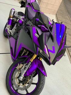 a purple and black motorcycle parked on the street