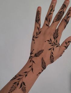 a person's hand with black leaves on it