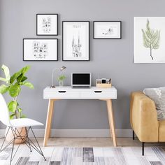 a living room with grey walls and pictures on the wall, a white desk in front of a couch