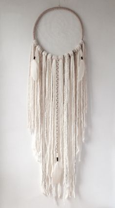 a white dream catcher hanging on the wall