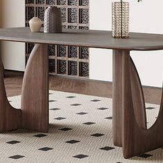 a wooden table sitting on top of a rug next to a vase filled with flowers