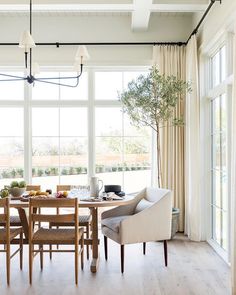 an image of a dining room setting with chairs and table in front of large windows