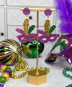 mardi gras decorations are displayed on a table with beads and feathers in the background