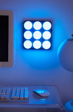 a computer monitor sitting on top of a desk next to a light that is blue