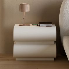 a white table with a lamp and books on it