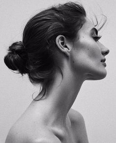 a black and white photo of a woman with her hair in a high pony tail