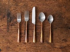 four forks, two spoons and one knife on a wooden table