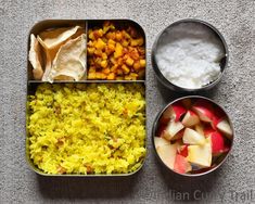 an open lunch box with rice, fruit and other food items