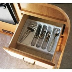 an open drawer with utensils in it