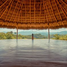 an advertisement for the yoga studio in front of a thatched roof with mountains in the background