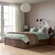 a bedroom with a bed, nightstands and windows