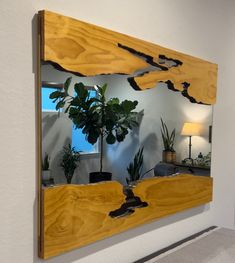 a mirror that is on the wall with some plants in it and a potted plant