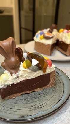 two pieces of cake on plates with chocolate and candy toppings in the shape of bunny ears