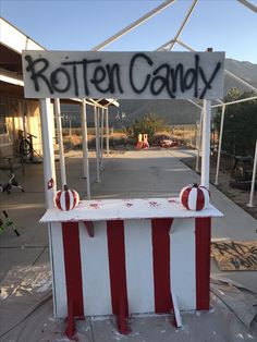 a sign that says rotten candy on the side of a building with red and white stripes