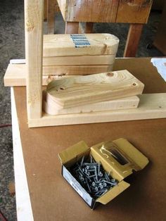 several pieces of wood sitting on top of a table next to a box with screws in it