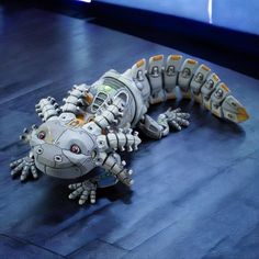 a toy lizard sitting on top of a wooden floor