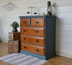 a wooden dresser sitting on top of a hard wood floor next to a white wall