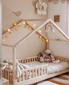 a wooden bed with a white canopy and lights on the ceiling, in a child's room