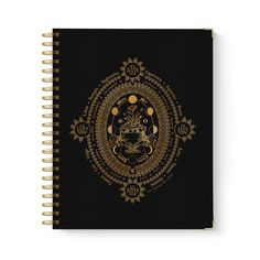 a spiral notebook with an intricate design on the front and back cover, featuring a golden buddha