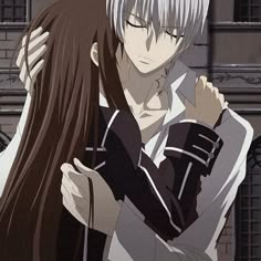 two anime characters hugging each other in front of an old brick building, one with long white hair and the other with dark brown hair