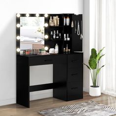 a black vanity with lights on it next to a potted plant