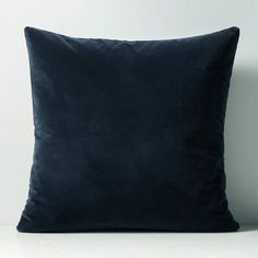 a black pillow sitting on top of a white table