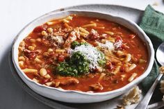 a bowl of pasta soup with broccoli and parmesan cheese