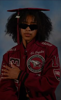 a woman wearing sunglasses and a red jacket with an eagle on it's back