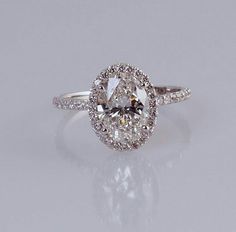 an oval cut diamond ring with halos and pave set shoulders