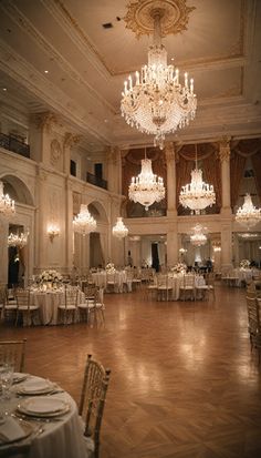 an elegant ballroom with chandeliers and tables