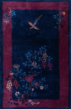 a blue rug with flowers and a bird flying over the area in front of it