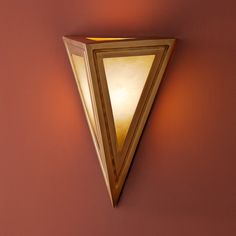 a wall light that is on the side of a wall with a triangle shaped shade