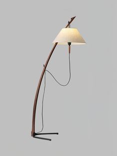 a lamp that is sitting on top of a wooden pole with a white shade over it