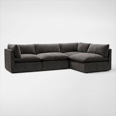 a large gray sectional sofa sitting on top of a white floor