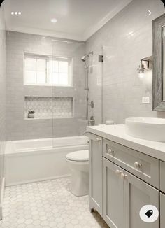 a white bathroom with hexagonal tile flooring