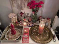 there is a tray with candles and other items on it, along with some flowers